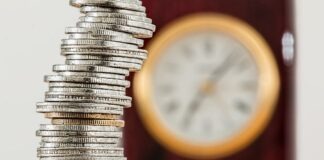 Exploring Opportunities: Banks for Sale in Latvia A close-up image of stacked coins with a blurred clock, symbolizing time and money relationship.