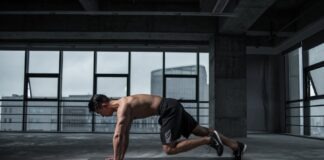 Fit man doing mountain climbers exercise inside a modern gym
