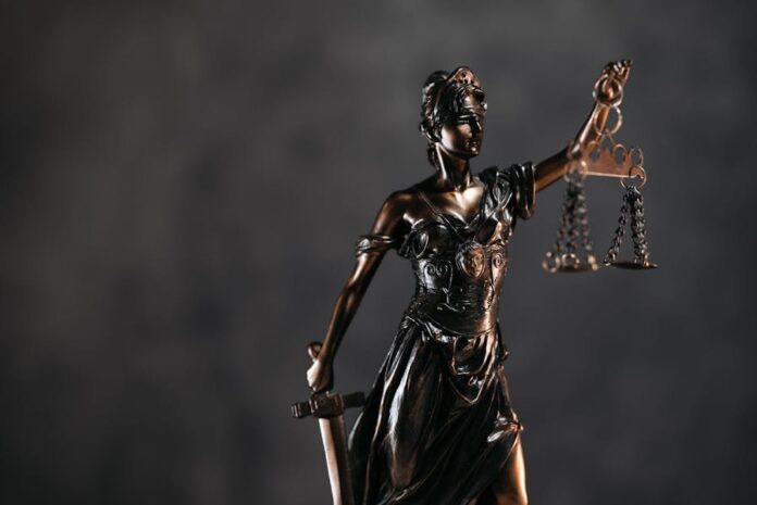 Photo by Pavel Danilyuk Detailed bronze Lady Justice statue with scales and sword against a dark background, symbolizing law and justice.