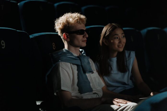 A couple watches a movie in a dark cinema, creating an intimate atmosphere.