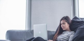woman sitting on sofa while using MacBook Pro