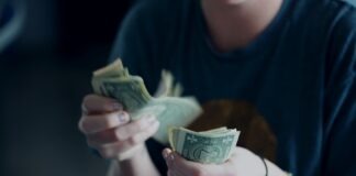 focus photography of person counting dollar banknotes