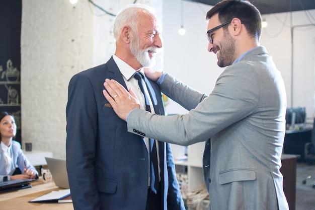 Happy businessmen greeting each other in the office