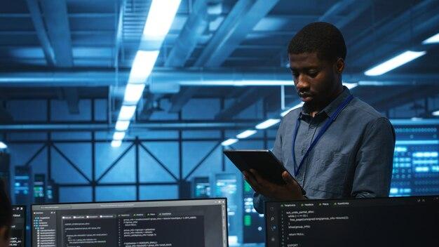Technician in server hub using tablet to find hardware misconfigurations