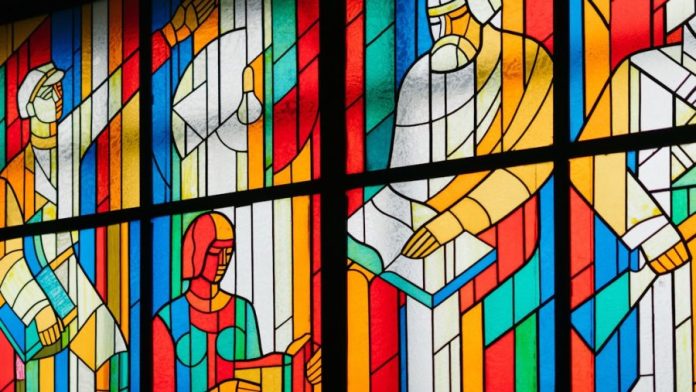 Photo by Ant Rozetsky man reading stain glass window