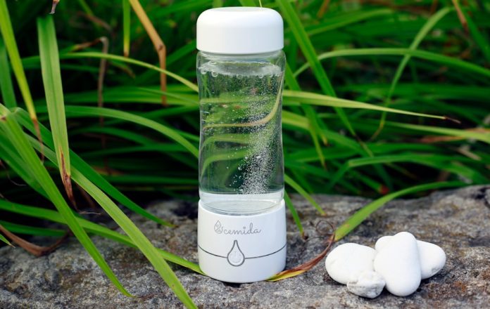 Photo by Pat DuBois a glass bottle with water inside sitting on a rock
