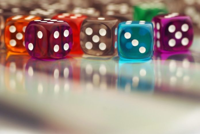 colourful-clear-dices-on-a-glass-surface Colourful clear dices on a glass surface