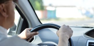 person in white long sleeve shirt driving car