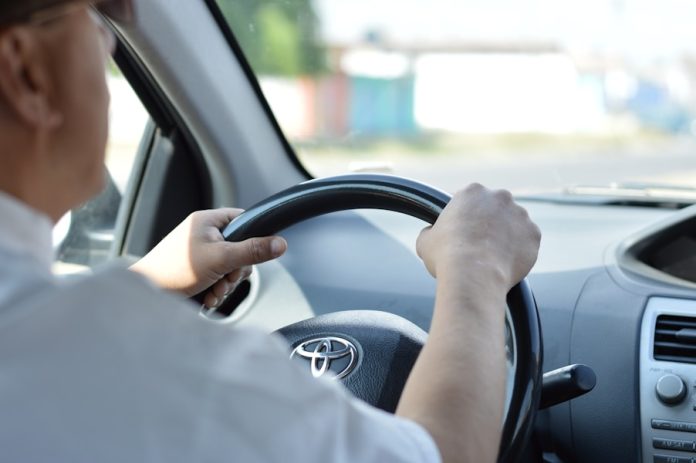 Photo by Rolando Garrido person in white long sleeve shirt driving car