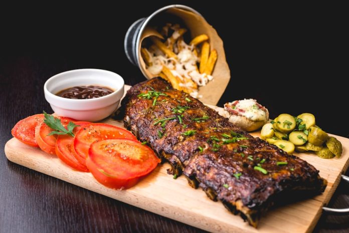 Photo by Alexandru-Bogdan Ghita roasted ribs with sliced tomatoes and potatoes