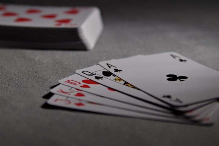 Photo by Pixabay Detailed view of playing cards displaying a winning poker hand in a dimly lit scene.