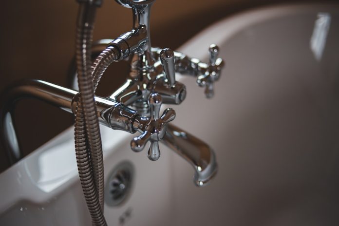Photo by Erik Mclean silver water faucet on white ceramic sink