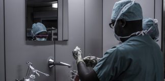 man wearing surgical suit near mirror