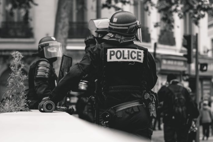 Photo by ev grayscale photo of Police standing and leaning on wall