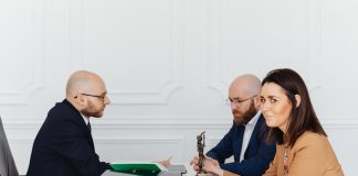 A lawyer consulting a couple in an elegant office setting, focusing on legal matters.