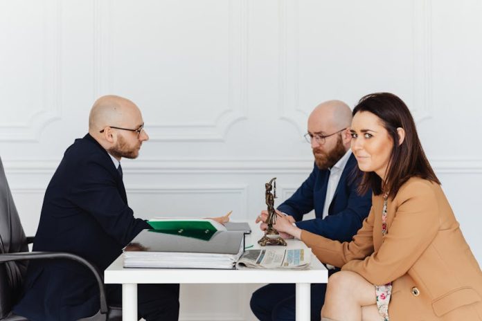 Photo by Photo By: Kaboompics.com A lawyer consulting a couple in an elegant office setting, focusing on legal matters.
