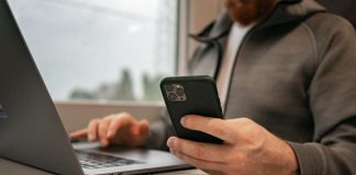 How to Deposit Money Online – Fast, Safe, and Simple Methods a man sitting in front of a laptop computer holding a cell phone