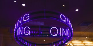 a neon sign hanging from the ceiling of a building
