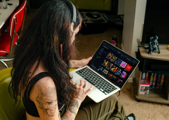 Photo by BandLab a woman sitting in a chair with a laptop
