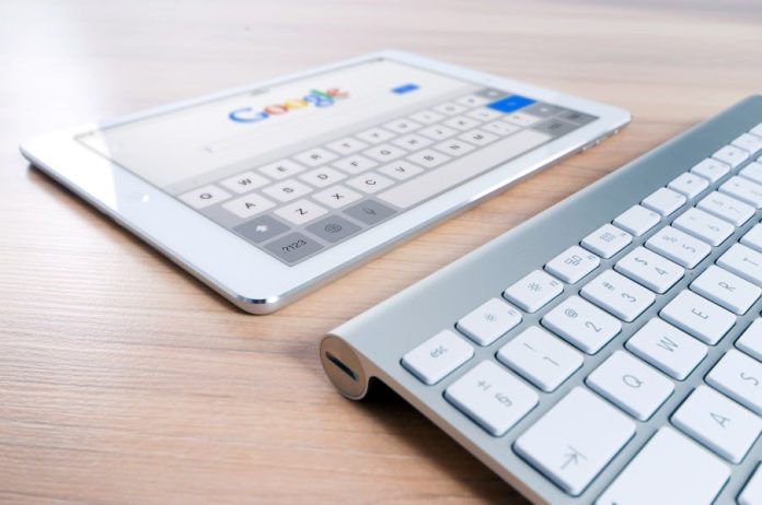 Photo by Pixabay A modern tablet displaying a search engine logo next to a wireless keyboard on a wooden desk.