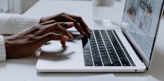 Hands typing on a sleek laptop keyboard, illustrating modern technology in use.