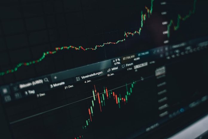 Photo by Alesia Kozik Close-up of a digital market analysis display showing Bitcoin and cryptocurrency price trends.