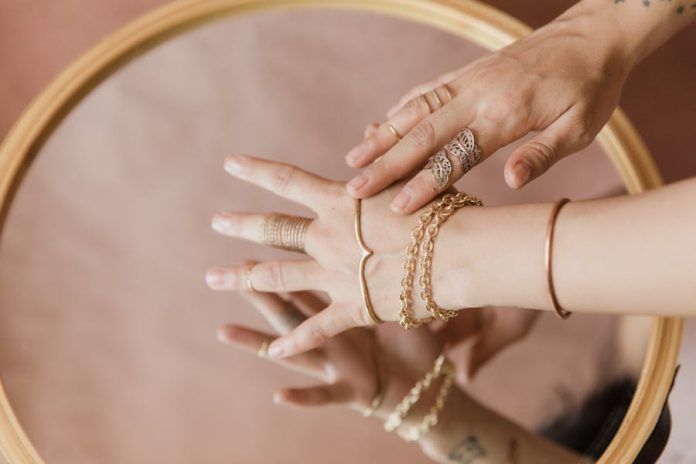 Photo by RDNE Stock project Close-up of elegant hands with jewelry, reflecting on a mirror surface.