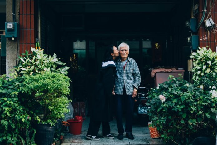 Photo by Treddy Chen woman kissing man standing