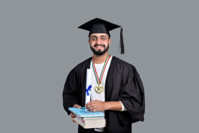 Photo by Fotos a man wearing a graduation cap and gown holding a book