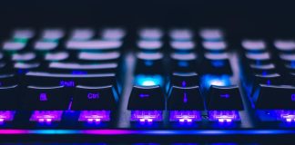 Best Game VPS Solutions for Lag-Free Gaming A detailed close-up of illuminated mechanical keyboard keys with focus on blue and purple lights.