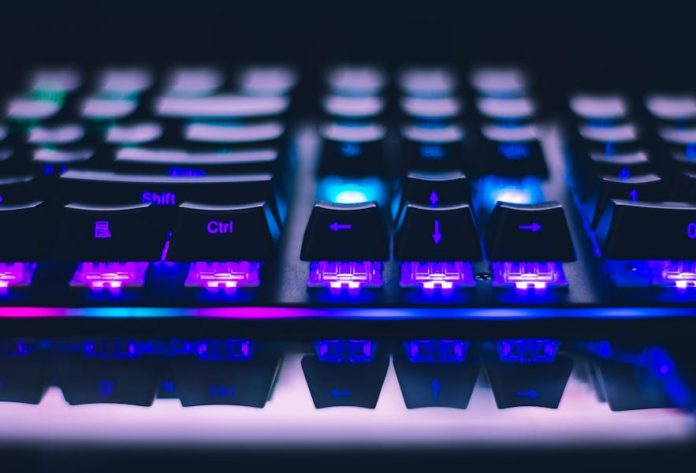 Photo by John Petalcurin A detailed close-up of illuminated mechanical keyboard keys with focus on blue and purple lights.