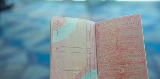 Know How Golden Visa Supports Immigration Goals Close-up view of an open passport displaying various travel stamps in an airport setting.