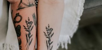 person with black and red floral tattoo on left leg
