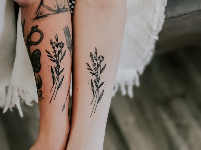 Photo by Randi Wilson person with black and red floral tattoo on left leg