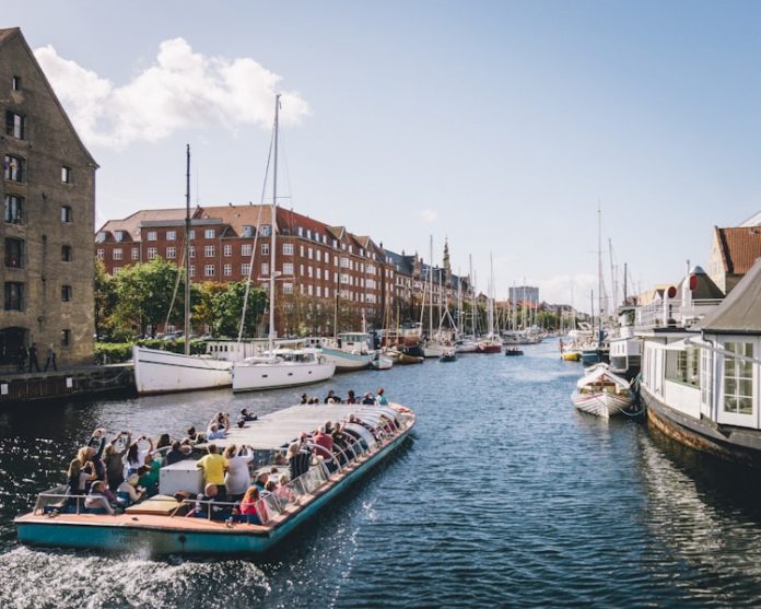 Photo by Kristijan Arsov people riding on boat on water near buildings during daytime