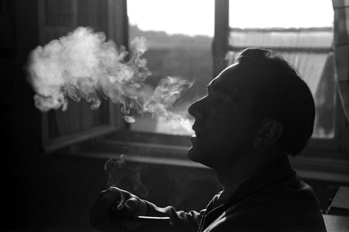 Photo by Sabine R person smoking beside window