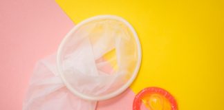 The Top Features to Look for in Ultra Thin Condoms red condom on pink and yellow surface