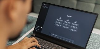 Close-up of a person typing on a laptop displaying the ChatGPT interface, emphasizing modern technology use.