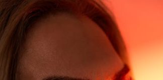 Artistic close-up portrait of a woman with warm, dramatic lighting.