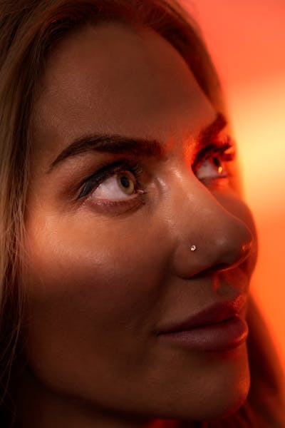 Photo by Lorenzo Manera Artistic close-up portrait of a woman with warm, dramatic lighting.