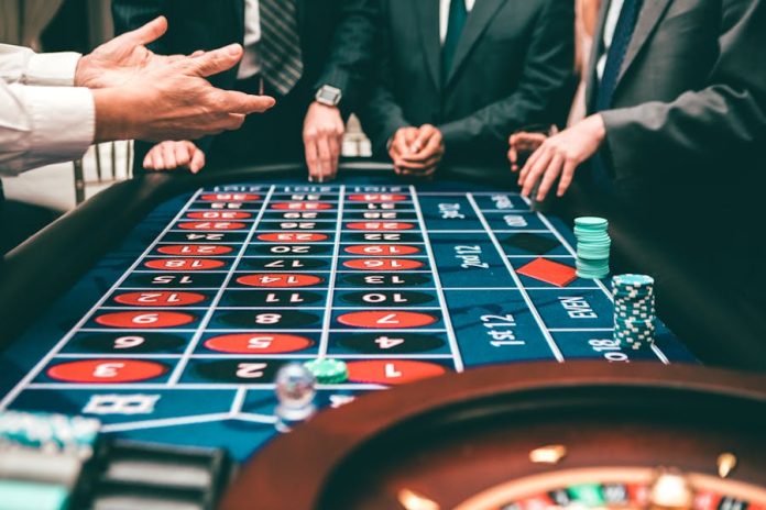 Photo by Javon Swaby Group of people playing roulette, placing bets in a casino setting.