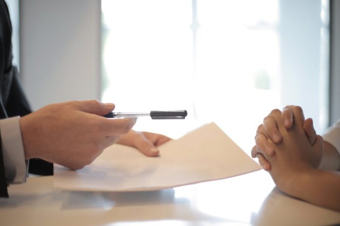 Photo by Andrea Piacquadio Close-up of a contract signing with hands over documents. Professional business interaction.