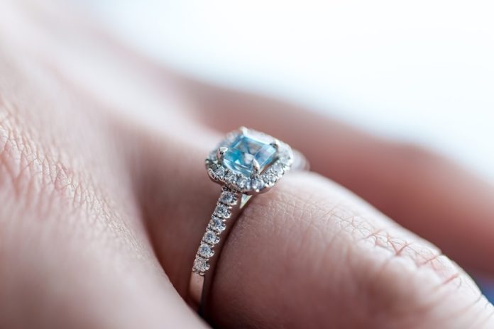 Photo by Andy Holmes person showing silver-colored ring with gemstone