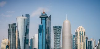 a group of tall buildings sitting next to a body of water