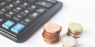 Why Payroll Management Is Crucial for Film Productions to Stay on Budget Close-up of stacked coins and a calculator symbolizing financial strategy and budgeting.