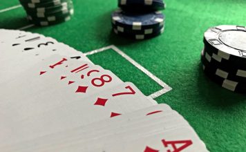 Close-up view of poker cards and chips on a green felt table, perfect for casino-themed content.