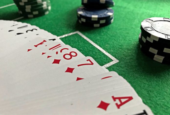 Photo by Aperture Pro Close-up view of poker cards and chips on a green felt table, perfect for casino-themed content.