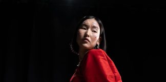 Miksi aasialaisten draamojen fanit rakastavat interaktiivista viihdettä A striking portrait of a woman with unique face paint wearing a red dress in a studio setting.