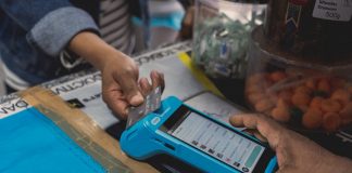 Unveiling The True Costs Of Credit Card Processing a person holding a cell phone in their hand