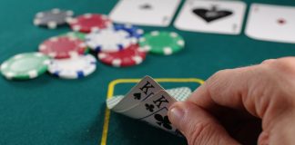 How Does Live Poker Online Compare to the Real Deal person holding white and black playing cards